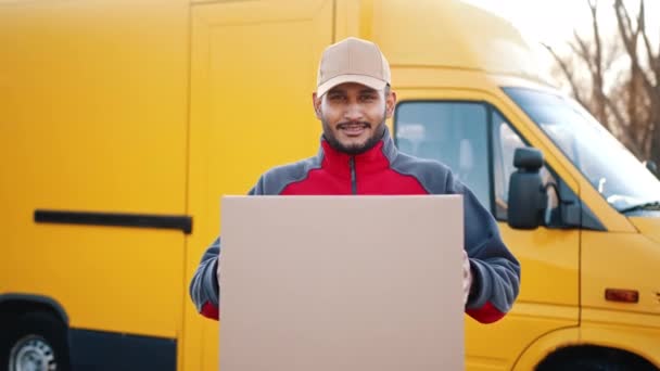 Delivery Boy hält eine Pappschachtel in der Hand - Bewegung der Schachtel in Richtung Kamera — Stockvideo