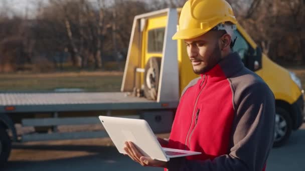 Inženýr nosí helmu drží notebook a pracuje kontrolu jeho plánované práce — Stock video