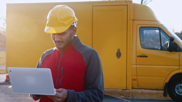 Mladý inženýr nosit bezpečnostní přilbu držení notebook kontrolu jeho plánované práce — Stock video