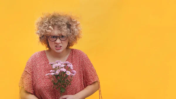 Schöne Mädchen mit einem Bündel Gerbera-Gänseblümchen, die wütend in die Kamera schauen — Stockfoto