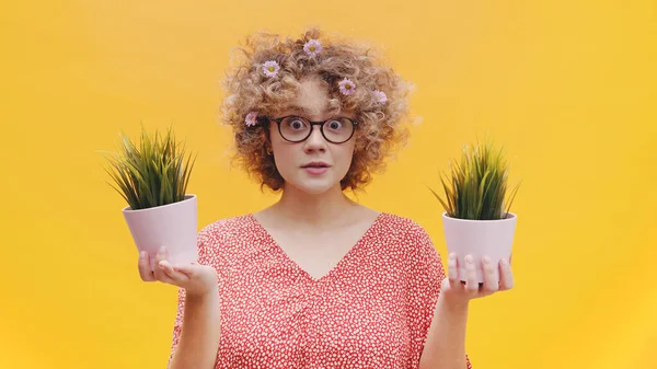 Schöne überrascht Mädchen hält zwei kleine Topfpflanzen in ihren Händen tragen Specs — Stockfoto
