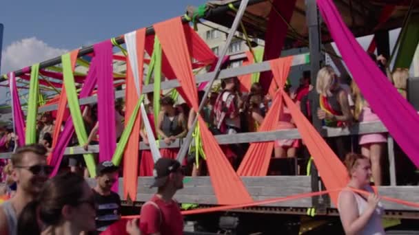 Marcha por los derechos LGBTQ en un desfile de orgullo. Rayas de colores en la caravana con la gente — Vídeo de stock