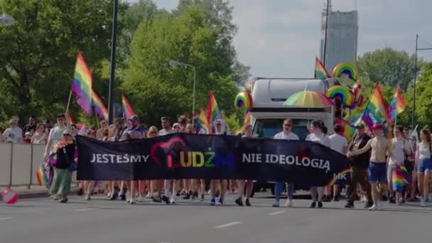 Marcia per i diritti LGBTQ in una parata di orgoglio. Persone con bandiere arcobaleno e passeggiate trasparenti per le strade — Video Stock