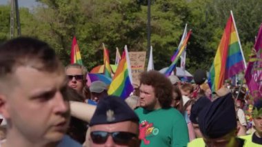 Varşova 'daki bir geçit töreninde LGBTQ hakları için yürüyüş. Gökkuşağı bayraklı her yaştan insan