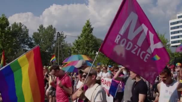 Pessoas no desfile de orgulho com bandeiras e guarda-chuvas arco-íris — Vídeo de Stock