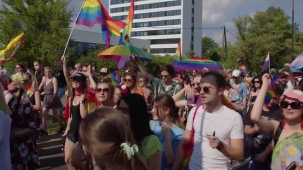 Persone felici che ballano con bandiere e ombrelli arcobaleno in marcia per i diritti LGBTQ in una parata di orgoglio — Video Stock