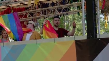 Onur geçidi. İnsanlar karavanda dans ederken gökkuşağı renkleriyle 