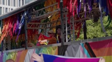 Onur geçidi. İnsanlar gökkuşağı renkleriyle karavanda dans edip şarkı söylüyorlar. 