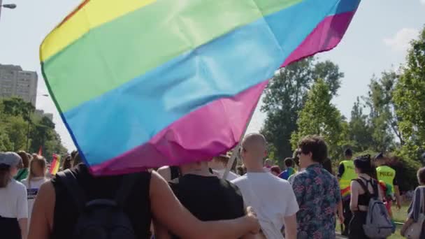 Pride Parade, Warschau. Rückansicht der Menschen, die mit Regenbogenfahnen laufen — Stockvideo