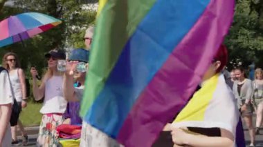 Varşova Şeref Yürüyüşü. Renkli giysiler içinde bir sürü insan ve lgbq 'a doğru ilerleyen gökkuşağı bayrakları.
