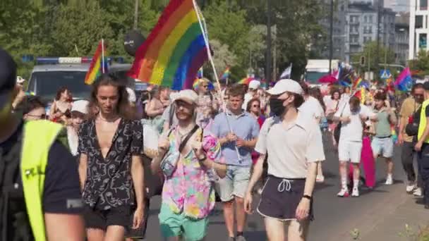 Stolthet parad Warszawa. Folkmassan av människor i färgglada kläder och med regnbåge flaggor marscherar för lgbq höger — Stockvideo