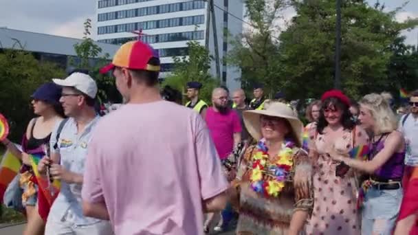 Trotse parade Warschau. Volk van mensen in kleurrijke kleding en met regenboog vlaggen marcheren voor de lgbq rechts — Stockvideo