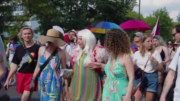 Trotse parade Warschau. Volk van mensen in kleurrijke kleding en met regenboog vlaggen marcheren voor de lgbq rechts — Stockvideo