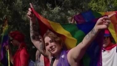 Onur geçidi. Renkli elbiseli ve gökkuşağı bayrağı taşıyan kadın lgbtq hakları için yürüyor