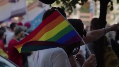 Onur geçidi. Renkli elbiseli ve gökkuşağı bayraklı kadınlar lgbtq hakları için yürüyorlar.