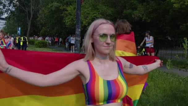 Trotse parade. Vrouw met kleurrijke kleren en regenboog vlag marcheren voor de lgbtq rechten — Stockvideo
