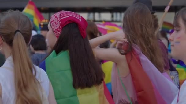 Parada de orgulho. Mulheres com roupas coloridas e bandeiras de arco-íris marchando para os direitos lgbtq — Vídeo de Stock