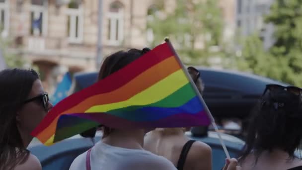 Stolthet parad. Kvinnor med färgglada kläder och regnbågsflaggor marscherar för lgbtq rättigheter — Stockvideo