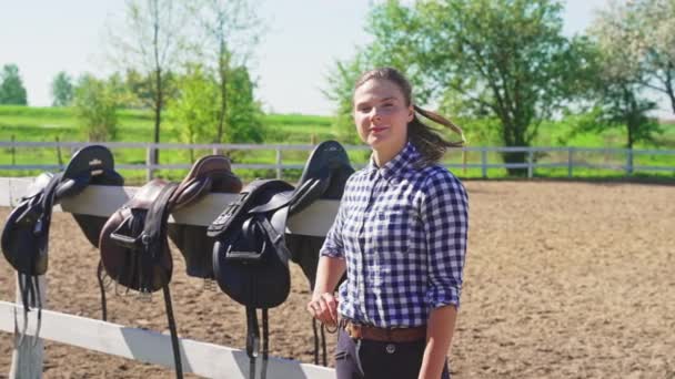 Zadels opknoping op de houten hekken - Meisje op de voorgrond maken Duimen omhoog — Stockvideo