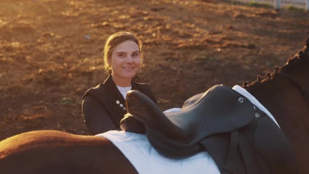 Jezdkyně stojící se svým hnědým koněm během deště - usmívající se na kameru — Stock video