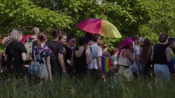 Kolorowe parasole i tęczowe flagi w rękach ludzi w Marszu na rzecz praw LGBTQ — Wideo stockowe