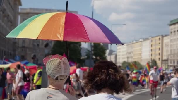 在争取LGBTQ权利的游行中，人们手里拿着彩色雨伞和彩虹旗 — 图库视频影像