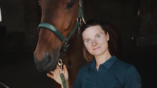 Всадница, глядя на свою темную лошадь с любовью улыбаясь и позируя с лошадью — стоковое видео