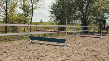 Kum Arenasında binen jokey engellerin üzerinden atlıyor.