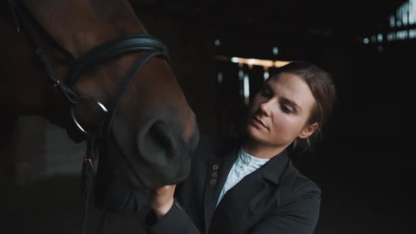 Właściciel konia Fixing Bridle z jej ciemnobrązowy koń w stajni - jazda konna — Wideo stockowe