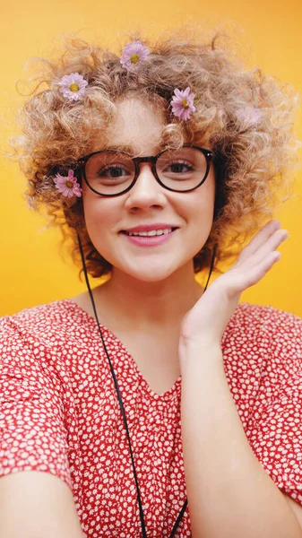 Lány visel kocka Specs és fülhallgató zenét hallgatni - Daisies a hajában — Stock Fotó
