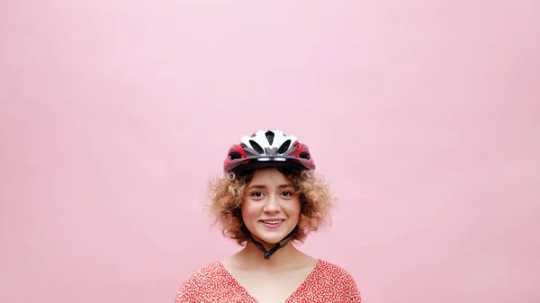 Hermosa chica joven con un casco de bicicleta sonriendo y posando para la cámara — Foto de Stock