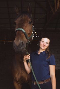 At sahibi, at ve efendisi arasındaki koyu kahverengi atıyla poz veriyor.