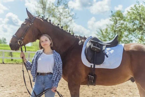 Mulher de cavalo com seu cavalo escuro da baía posando para a câmera na arena arenosa — Fotografia de Stock