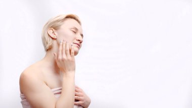 Vücuduna havluyla sarılı güzel sarışın bir manken, spa konsepti.