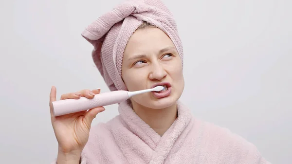 Menina segurando uma escova de dentes elétrica escovando seu conceito de dentes de cuidados orais — Fotografia de Stock