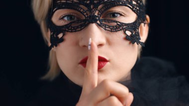 Venedik maskeli maskeli, dudaklarında maske, dudaklarında jestler olan sarışın kız.