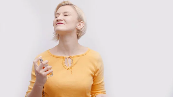 Girl Holding A Bottle Of Perfume Spraying The Perfume On Neck With Eyes Closed — Stock Photo, Image