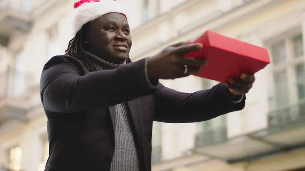 Un hombre negro quiere darle un regalo empaquetado a alguien — Foto de Stock