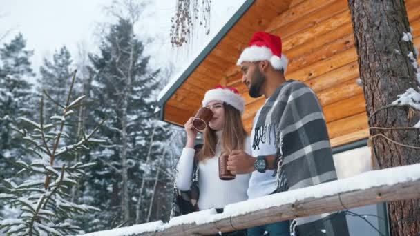 Cuplu tânăr în fața casei este băut și vizionarea cu pălărie Santas în depărtare — Videoclip de stoc