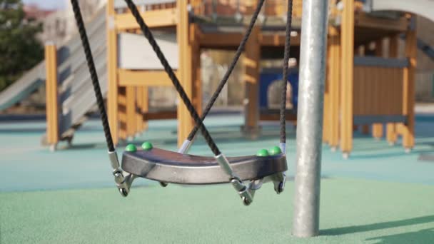 Empfehlen, die Schaukel nicht weit vom Kletterer auf dem Spielplatz zu verschieben — Stockvideo