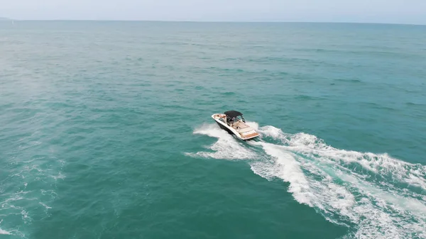 Motorový člun plachtění v tyrkysové moře dělat pěnové vlny letecký pohled - Seascape — Stock fotografie