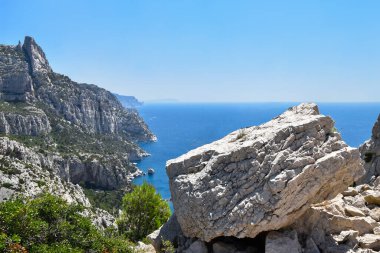 Fransa 'nın Marsilya kenti yakınlarındaki Calanques Ulusal Parkı' nın arka planında büyük bir kaya parçası var.
