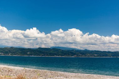 Mavi gökyüzüne karşı deniz ve dağlar