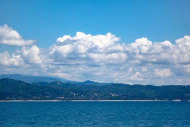 Mavi gökyüzüne karşı deniz ve dağlar