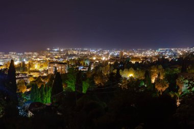 Gökyüzüne karşı ışıkları olan bir gece şehri.