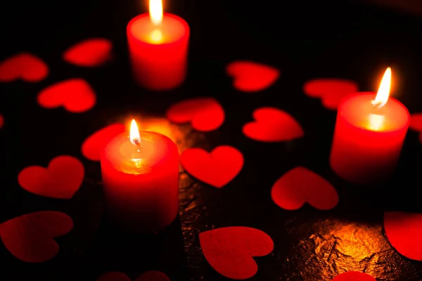 Fundo preto com velas e corações no dia dos namorados — Fotografia de Stock