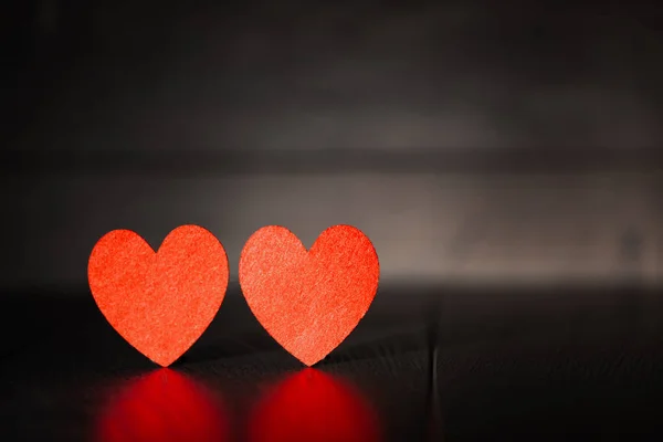 Tahta bir arka planda iki kırmızı kalp. — Stok fotoğraf