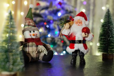 Noel Baba ve kardan adam Noel ağacının arkasında