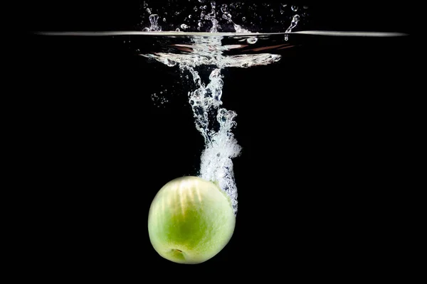 Jedno dojrzałe zielone jabłko wpadło do wody — Zdjęcie stockowe