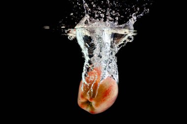 Olgun kırmızı elma suya düştü.